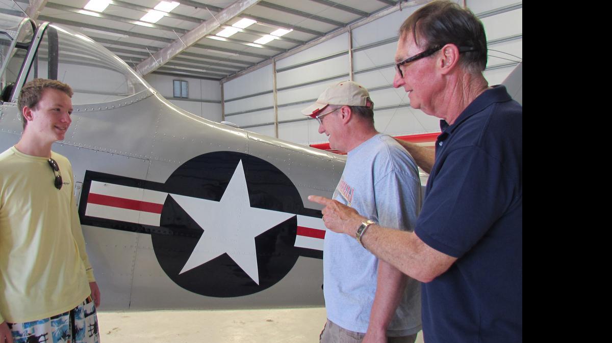 
Travis Franklin (from left); his father, Wayne Franklin; and his grandfather, Howie Franklin, admire the Air Force star insignia on a vintage World War II airplane at Cape Fear Regional Jetport in Oak Island, N.C. Howie Franklin will speak about his years as chief flight steward aboard Air Force One at the Museum of Coastal Carolina July 14.

