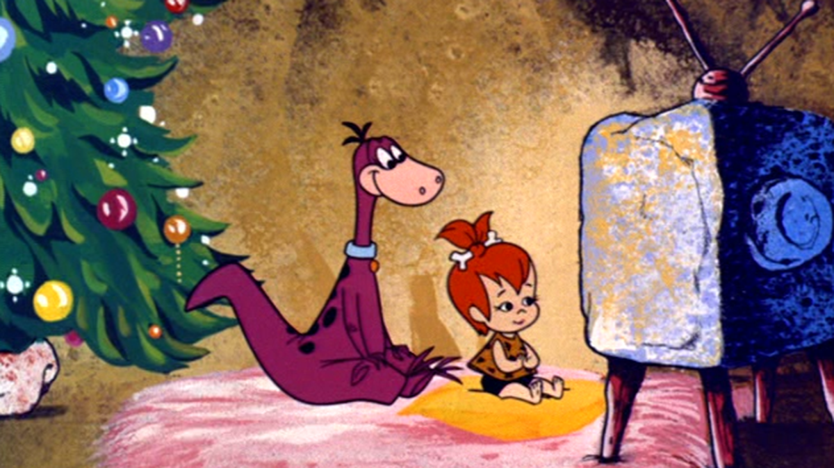 This photo shows the characters Dino the dinosaur and Pebbles from “How the Flintstones Saved Christmas,” an episode that aired originally as “Christmas Flintstone,” in 1964 on ABC, during the fifth of six seasons of “The Flintstones.”