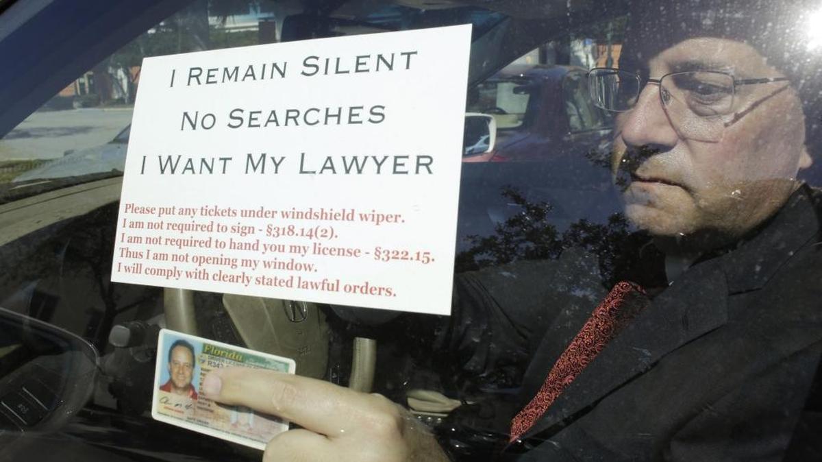 In this Friday, Jan. 30, 2015 photo, attorney Warren Redlich holds up a flyer he designed following an interview in Delray Beach, Fla. The DUI attorney contends that when a driver approaches a police drunk-driving checkpoint, they don’t have to speak to the officers. He contends that commonly-used police drunk driving checkpoints violate drivers’ constitutional rights.