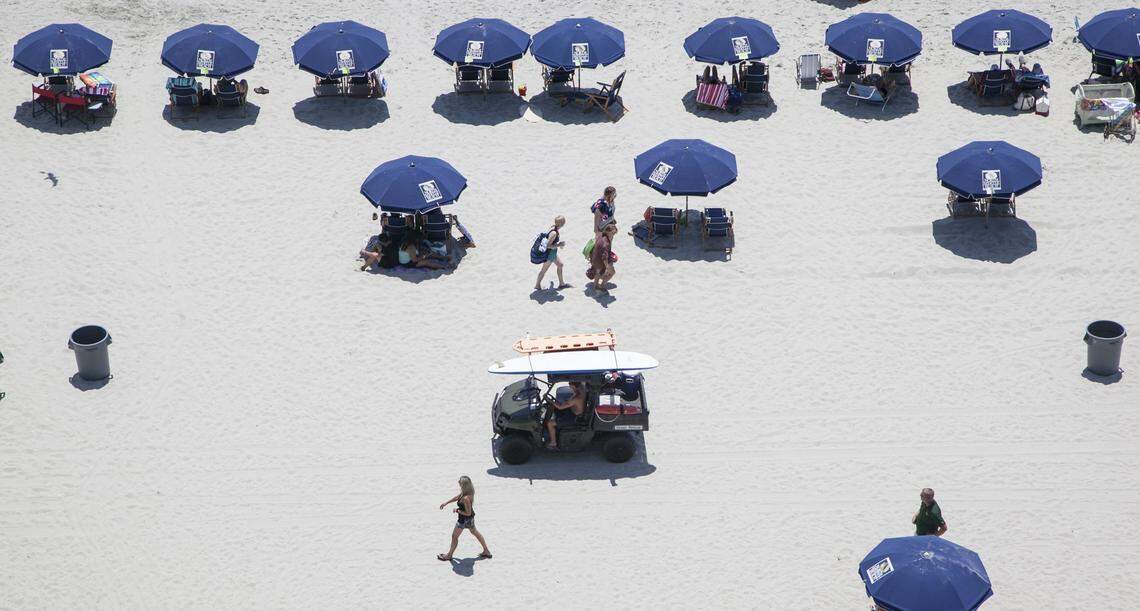 A lifeguard passes umbrellas and chairs for rent in North Myrtle Beach.