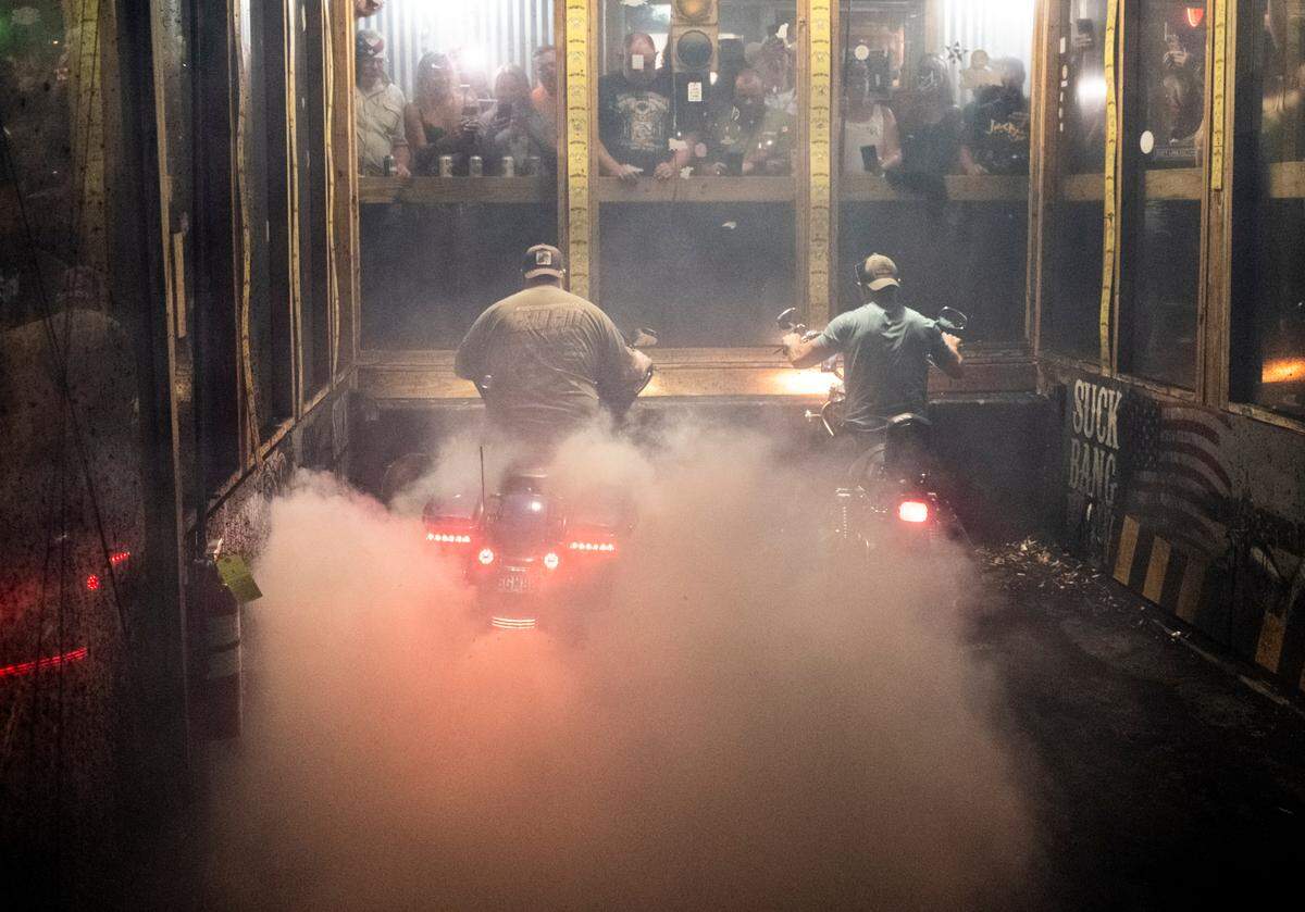 Bikers compete in the burnout pit at Suck Bang Blow bar in Murrells Inlet, S.C. during the 2024 Myrtle Beach Spring Rally. Their spinning tires burn rubber often shredding tires and filling the air with smoke, the roar of engines and the cheers from the crowd. May 16, 2024.