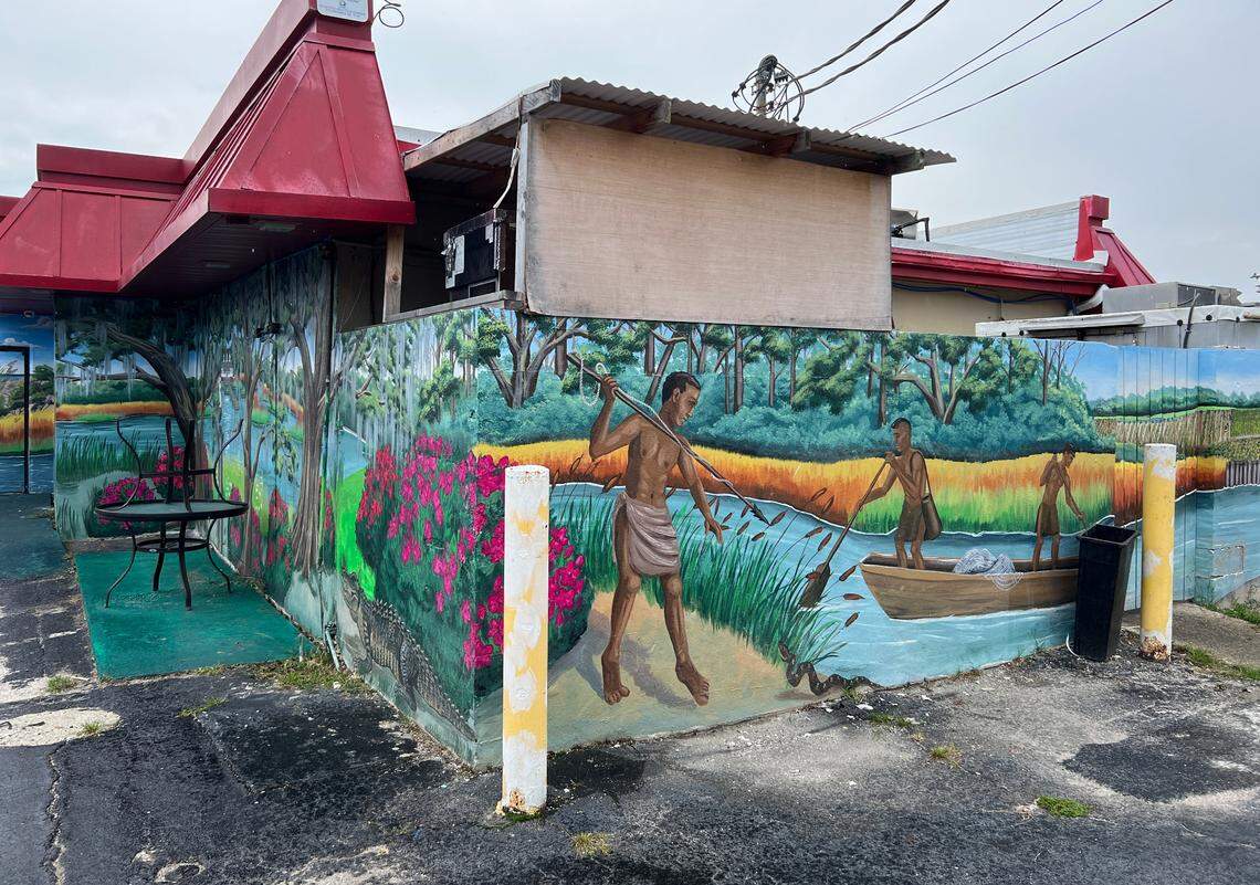Mural of Yammassee native American tribe fishing the shoreline of Wither’s Swash painted on the side of Cackalacky Fish Company by local artist April Bensch.