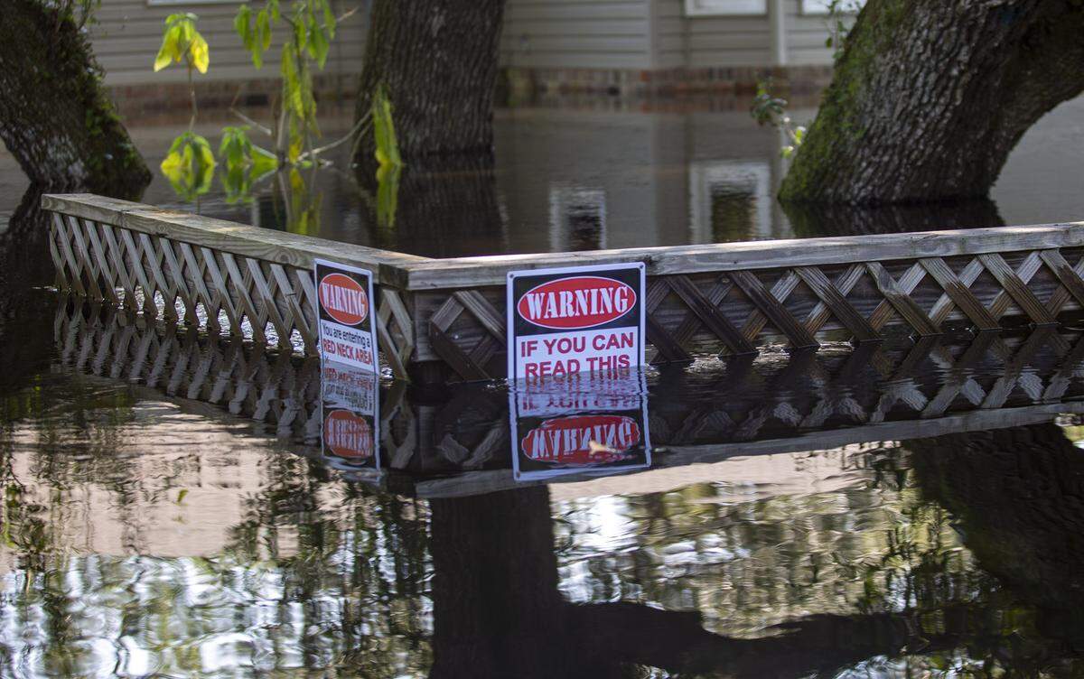 Water covers a portion of a sign on Pitch Landing Drive in Conway. Rising flood waters have made many homes in the southern Conway area inaccessible by car, so residents have begun launching boats to retrieve personal belongings and valuables.