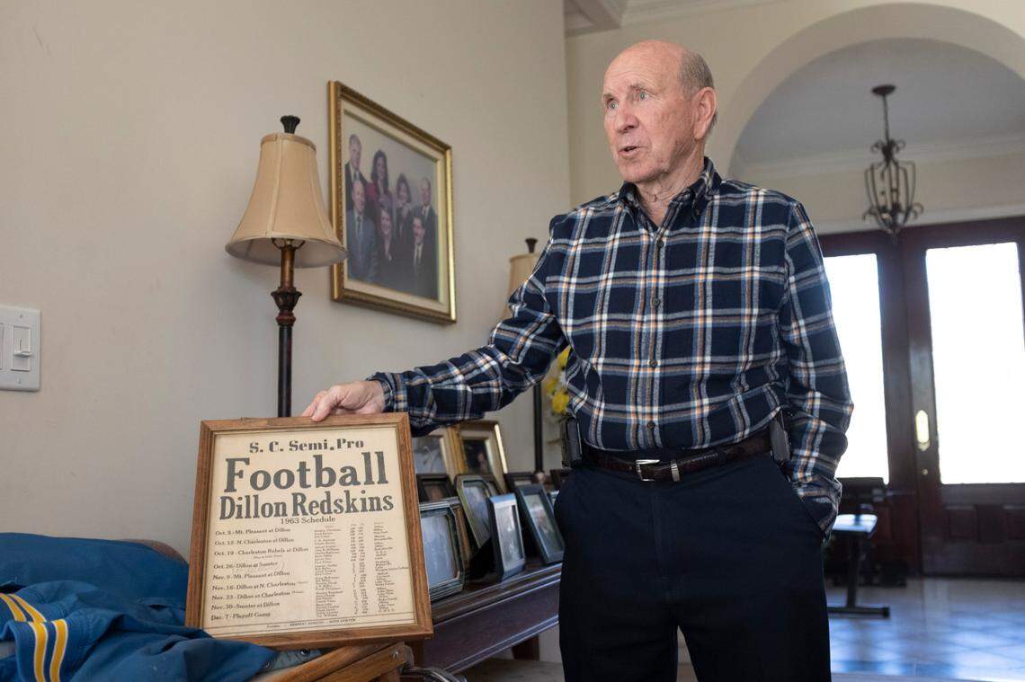 Horry County Councilman Paul Prince at home on Nov. 20. He holds up a framed roster of the minor league football team he played on, which was affiliated with the Washington Footbal Team.