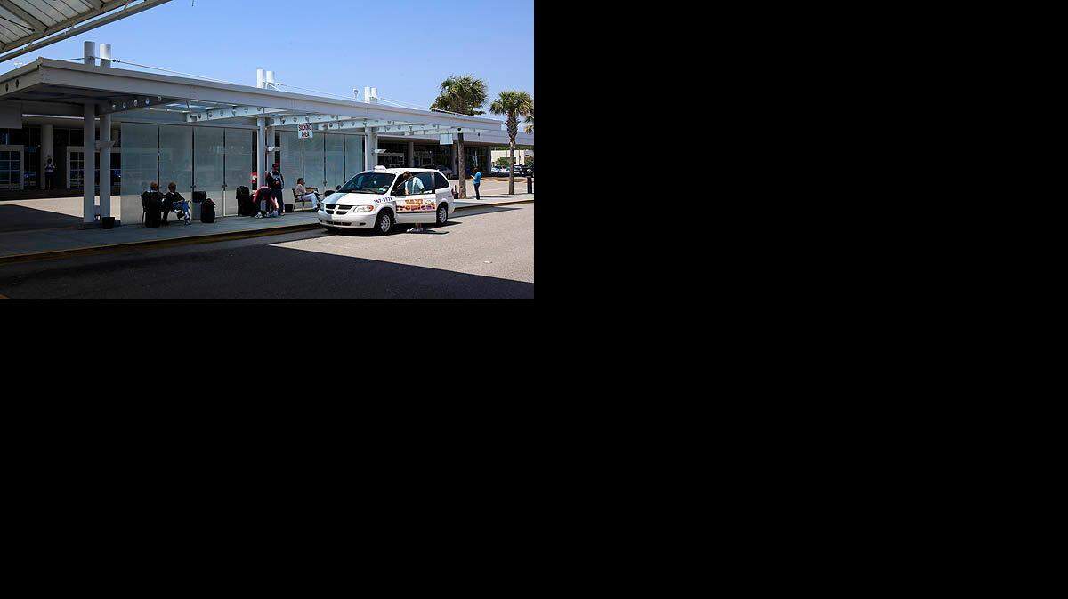 Passengers wait for taxis outside the Myrtle Beach International Airport.