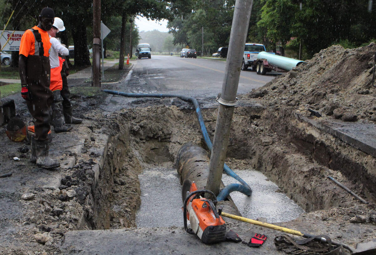 Workers stop work when the rain came down while they were repairing an corroded sewage pipe in Myrtle  Beach that spilled more than 100,000 gallons of sewer water Monday morning.