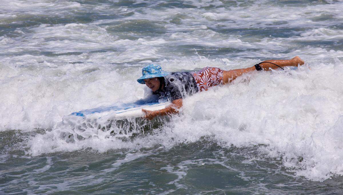 A new surfer catches waves near the Springmaid Pier. The week of July 4th is one of the times for tourism in the Myrtle Beach area. July 2, 2024.