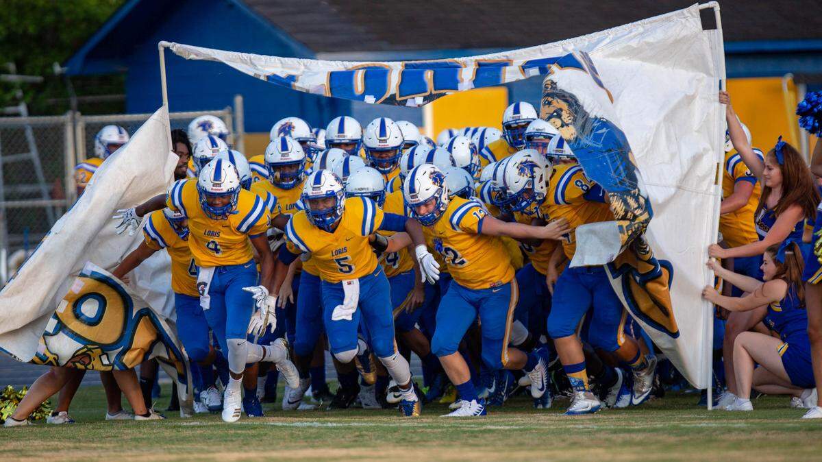 The Loris Lions take the field before a game against the St. James Sharks Friday night at Heniford Field in Loris.