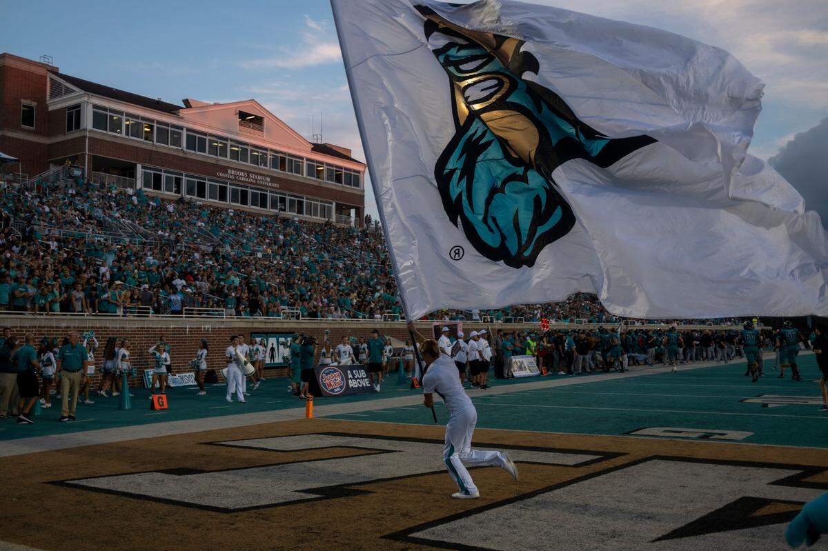 Coastal flags fly as the Chanticleers score their first touchdown against Army. Coastal Carolina University beat Army in the first game of the 2022 season at Brooks Stadium 38-28. A record crowd of 21,165 attended the game. Sept. 3, 2022.