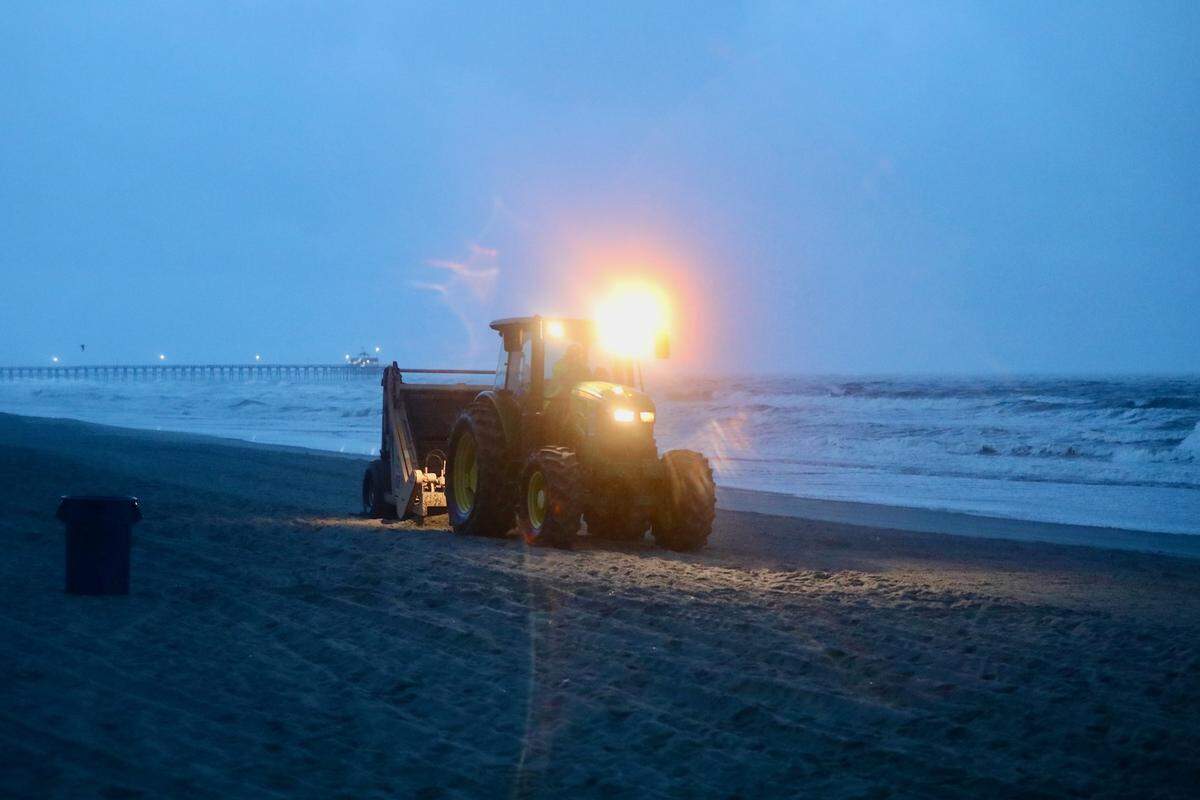 Tractors sweep trash from the beach in North Myrtle Beach, SC ahead of Tropical Storm Debby. Jason Lee/The Sun News