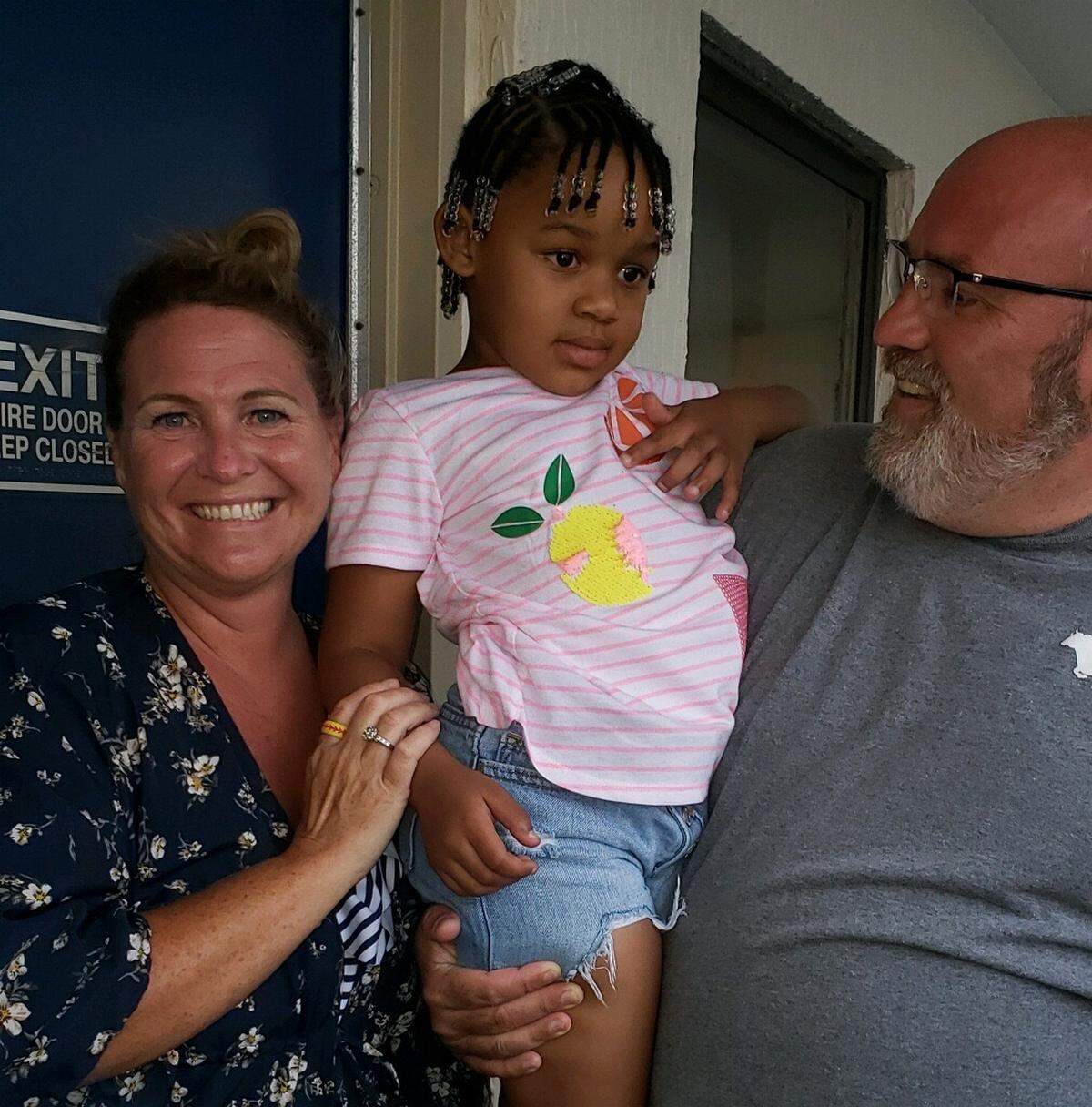 Erin and Joseph Russell, of Durham, North Carolina, embrace five-year-old Andrea, who they saved in August 2020 from drowning by performing CPR on her at Ocean Reef Resort in Myrtle Beach.