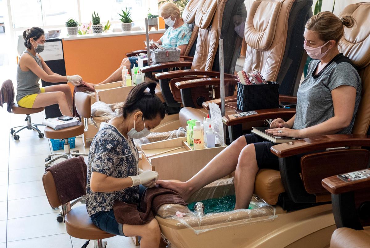 Customers receive pedicures on Monday morning at Four Seasons Nails & Spa in Murrells Inlet. The spa resumed operations on Monday following new SCDEC guidelines during the coronavirus pandemic including limiting customers, wearing masks, and using plexiglass dividers. . May 18, 2020