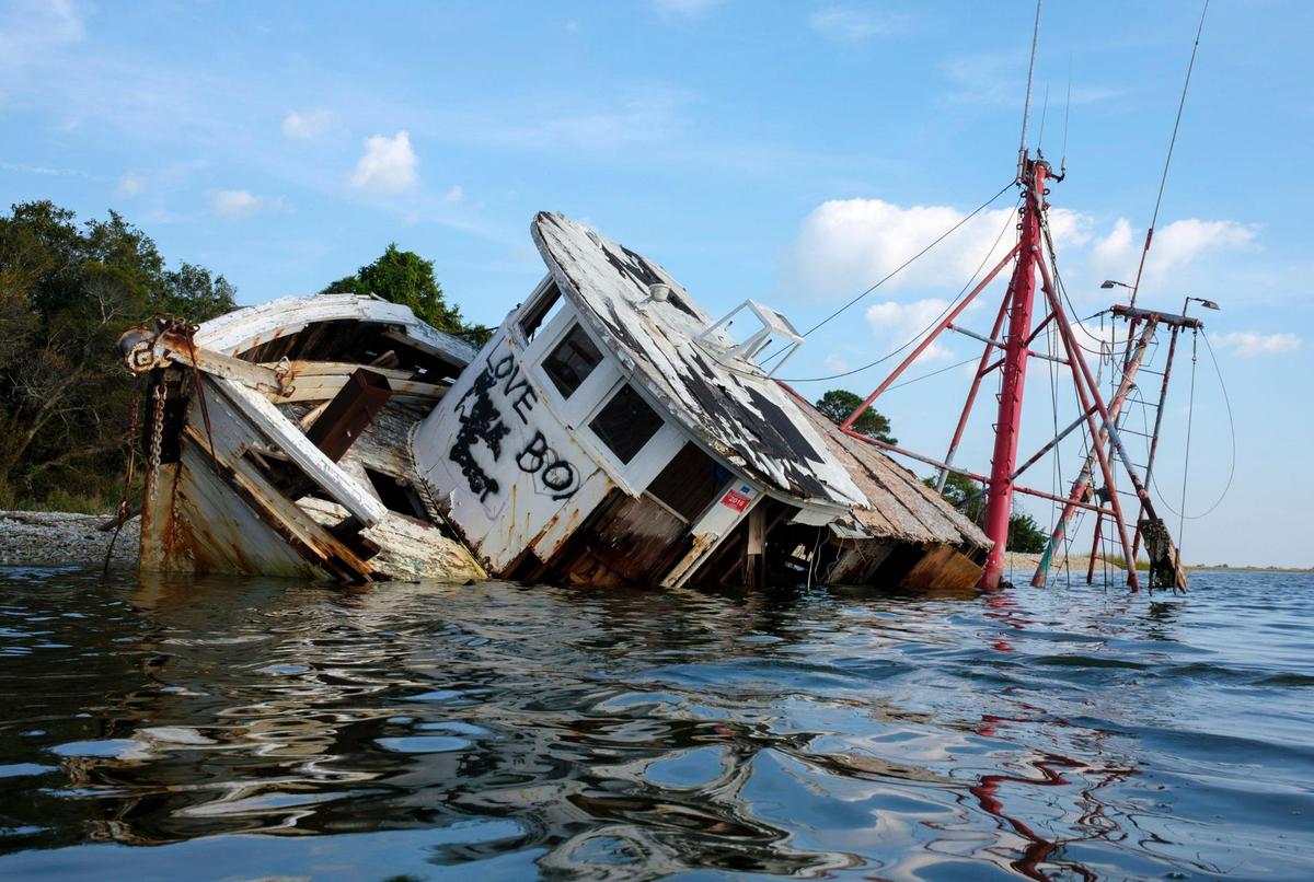 An abandoned shrimp boat called ‘Sum Day’ that was wrecked on the shoreline of the Intracoastal Waterway between Little River and Calabash, was removed in a joint effort by the South Carolina Natural Resources, the conservation group Wounded Natural Working Veterans, and local volunteers from Black Water Dredging. Abandoned boats litter the waterways throughout Horry County, S.C. The Department of Natural Resources is partnering non-profit conservation groups and local businesses to begin removing the derelict vessels from local waterways. Oct. 14, 2021.
