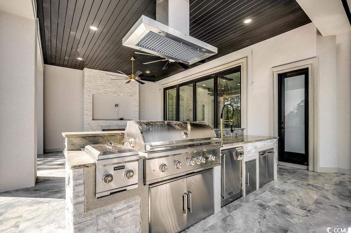 One of the patio space’s found at the Grande Dunes home. It has a grilling area as well as space for outdoor furniture and a TV.