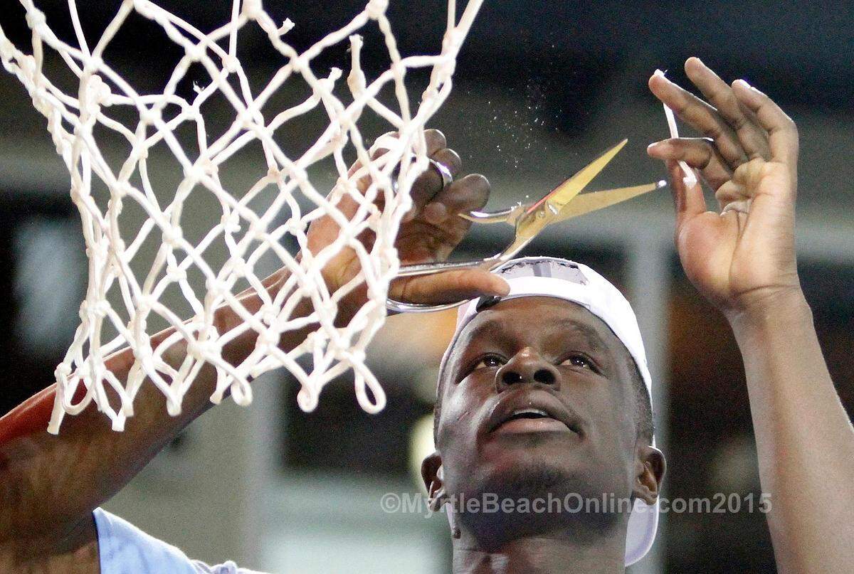 Coastal Carolina’s Badou Diagne snips off a piece of net as the team celebrates heading to the 2015 NCAA tournament after beating Winthrop 81-70 in the Big South championship on Sunday, March 8, 2015.