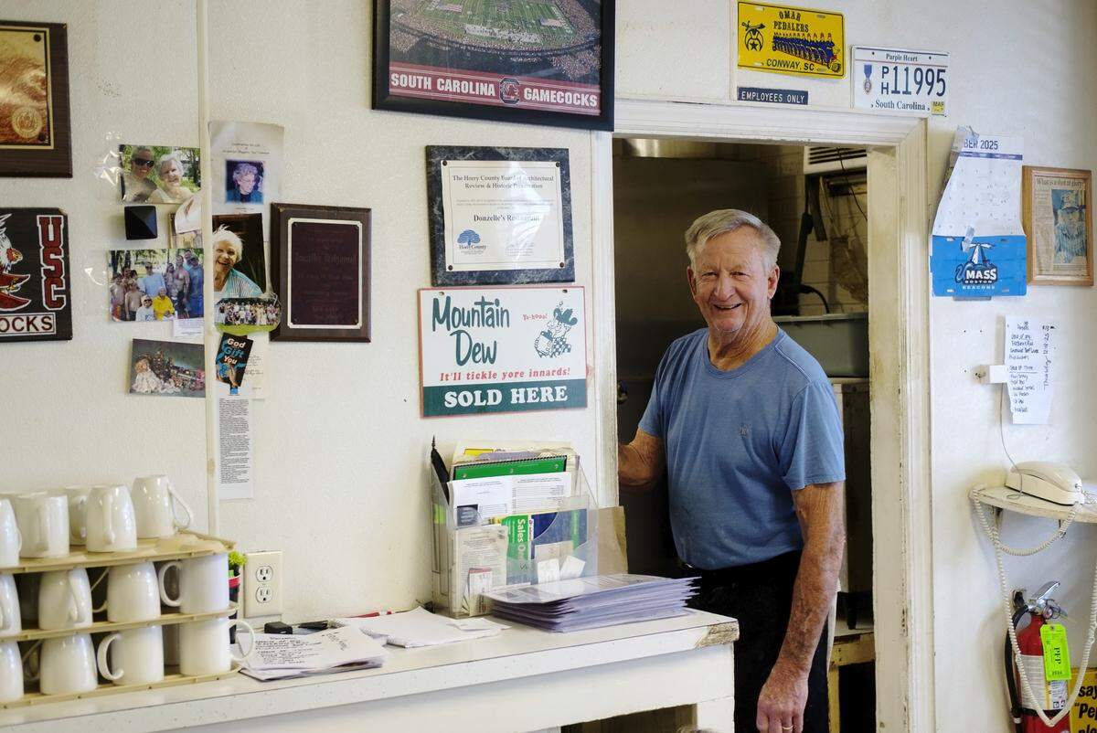 Larry Dickerson, co-owner of Donzelle’s Restaurant, often sticks his head out the kitchen to chat with customers. Conway locals are making their final visits to Donzelle’s Restaurant. A  favorite for more than 60 years, the eatery is known for both it’s comfort food and it’s social atmosphere. Founded by Donzelle and Dick Dickerson in 1962 and run by three generations of the family, Donzelle’s will close its doors on Christmas Eve. December 17, 2025.