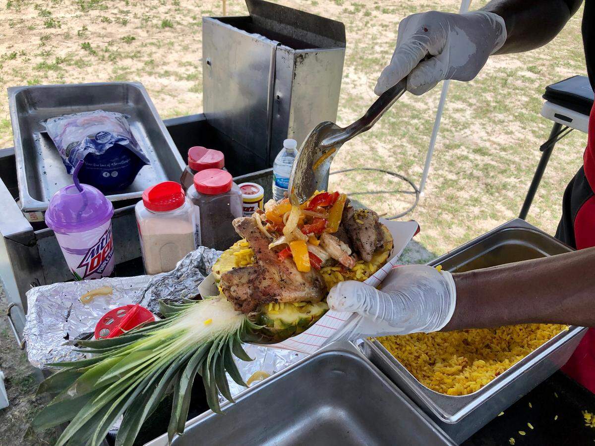 Donni Greene of Donnie’s Grill in Bucksport, S.C. assembled a pineapple bowl, with chicken, beef, shrimp and rice in a hollow pineapple. Food vendors served up delicious flavors at the Atlantic Beach Gullah Geechee Festival. June 24, 2023.