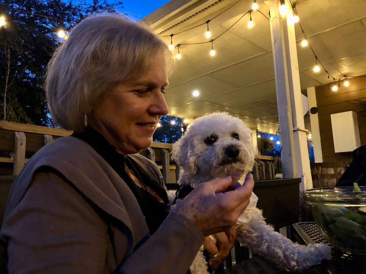 Owner Terri Usher feeds Cody, a two-year-old bichon, chicken jerky. The Sneaky Beagle restaurant, near Carolina Forest, has a seperate menu for dogs. January 3, 2022.
