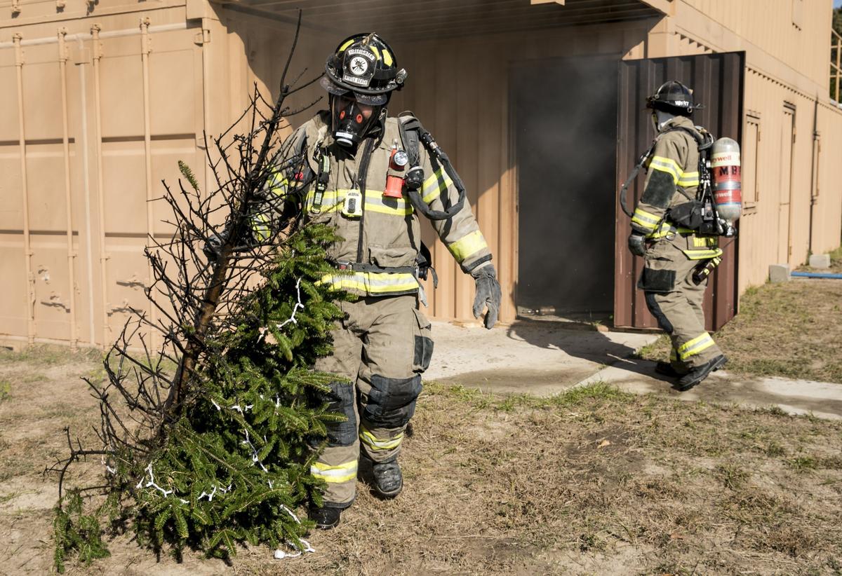 Firefighters remove a burned Christmas tree following a tree burning demonstration on Thursday. The demonstration was held for local media and the mayor in order to get the word out about fire safety around the holidays. Nov 29, 2018.