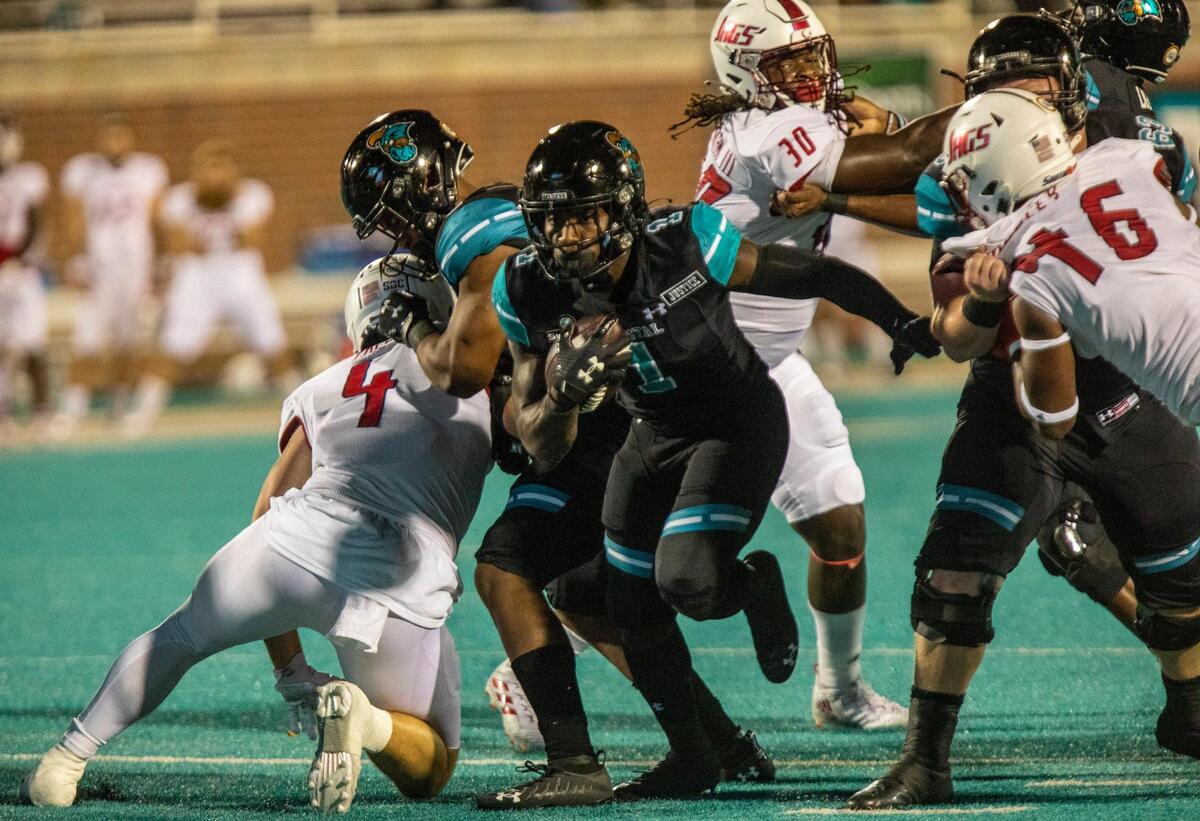 Coastal’s C.J. Marable breaks away from South Alabama defenders on Saturday at Brooks Stadium in Conway. November 8, 2020.