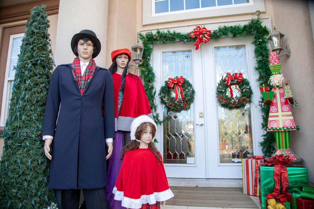 Mannequins dressed as Christmas carolers stand along the entrance to Ella Nixon’s home in Plantation Lakes.