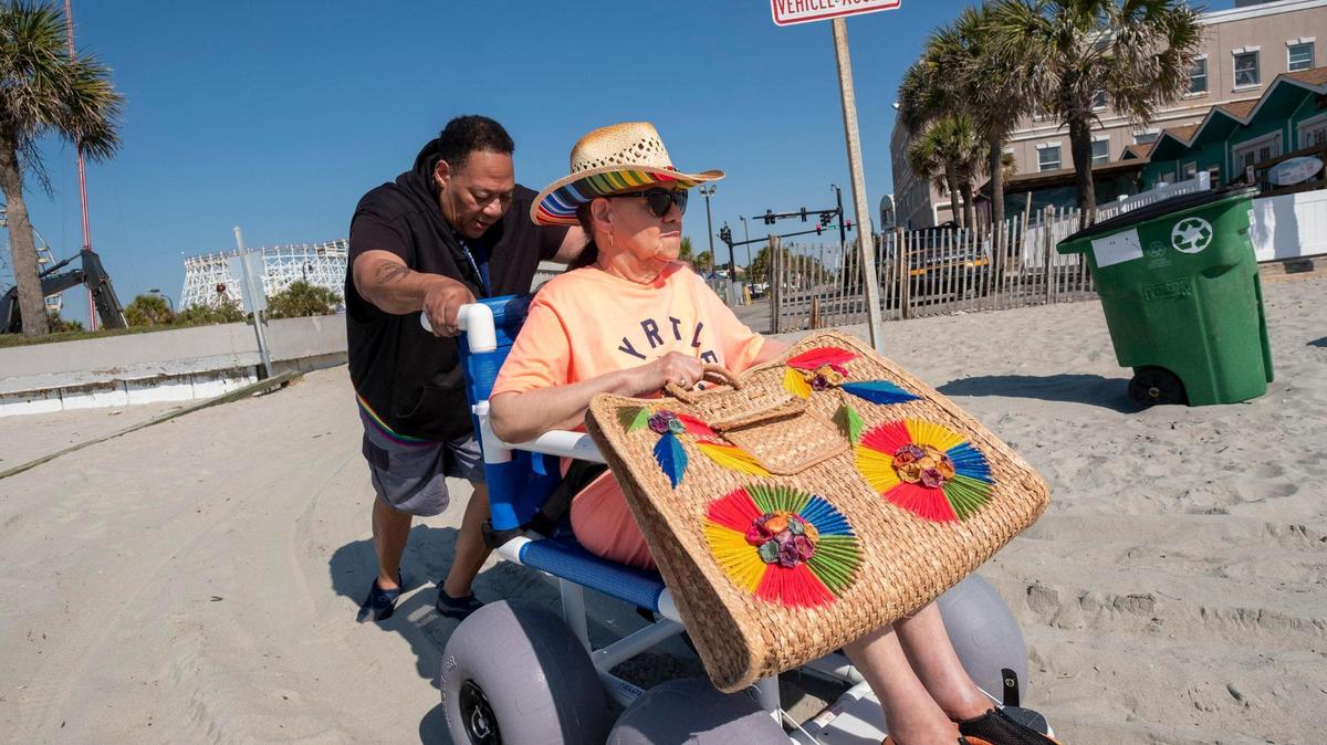 Unita Knight takes her mother, 90-year-old Joan Pulliam, to their favorite beach access in wheelchair to have her their portraits made. The City of Myrtle Beach and the non-profit Adaptive Surf Project are partnering to bring free beach wheelchairs back to Myrtle Beach, after the city discontinued them during the pandemic. April 19, 2023.