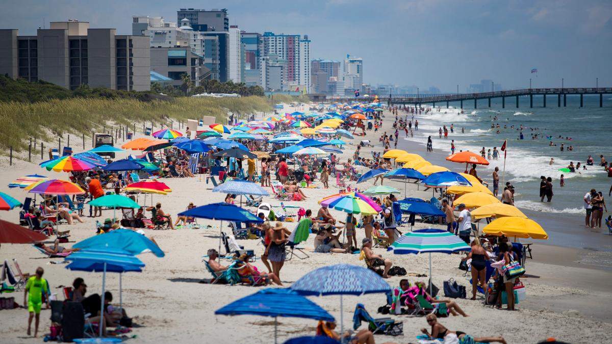People sit along the beach at Myrtle Beach State Park in Myrtle Beach on a Saturday afternoon in 2020. TSN 2020 File.