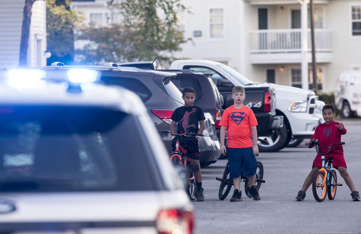 Children watch at the scene of a shooting at Flintlake Apartments where two people died on Wednesday evening, May 2, 2018.