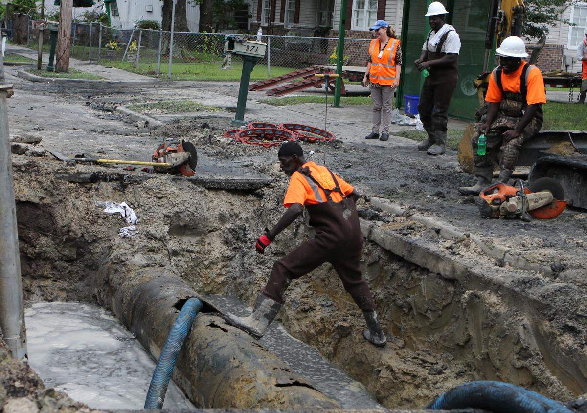 Workers repair an corroded sewage pipe that spilled more than 100,000 gallons of sewer water Monday morning.