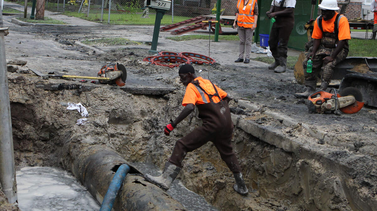 Workers repair an corroded sewage pipe that spilled more than 100,000 gallons of sewer water Monday morning.