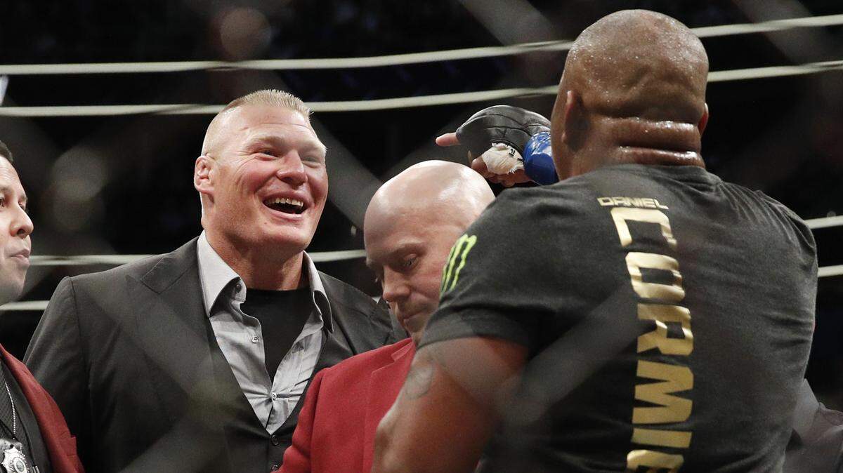 Brock Lesnar, left, taunts Daniel Cormier after Cormier's heavyweight title mixed martial arts bout at against Stipe Miocic at UFC 226, Saturday, July 7, 2018, in Las Vegas.