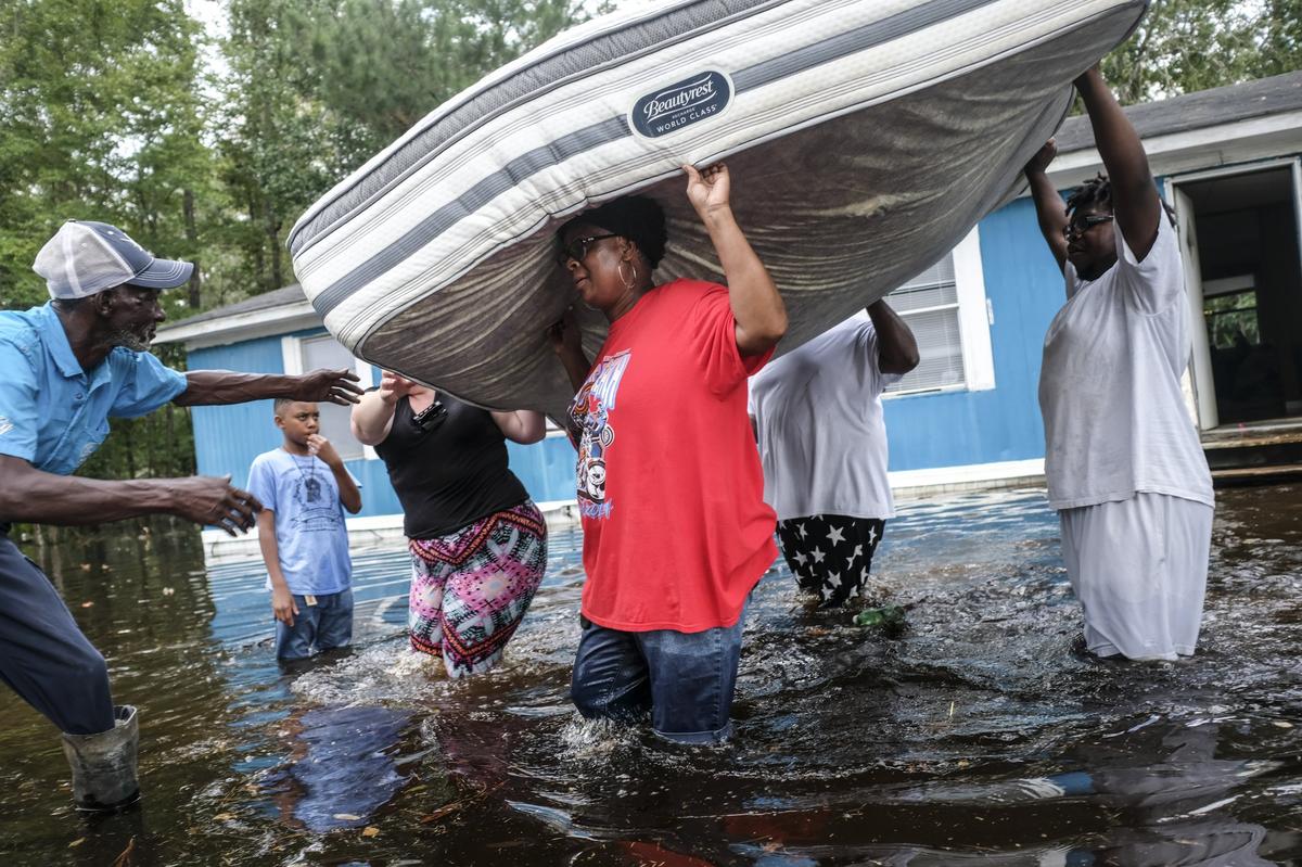 The Williams family off Collins Road in Longs rapidly removed their belongings trying to keep their mattresses dry. Water began flooding the small community of Longs late in the week touching some homes that did not expect to suffer the flood’s wrath. September 21, 2018.