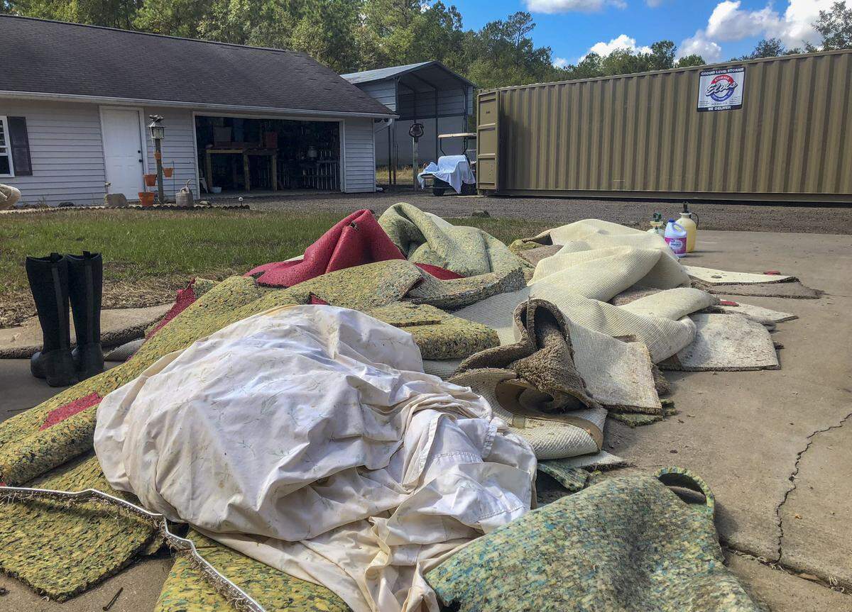 Piles of carpet and padding lie in a pile in the driveway of Joan Altman of Gallivants Ferry Tuesday.  Altman’s home took more than a foot of water.