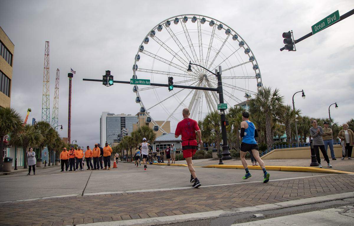 Runners move northbound past the SkyWheel on Ocean Boulevard during the 22nd annual Myrtle Beach Marathon Saturday in Myrtle Beach.