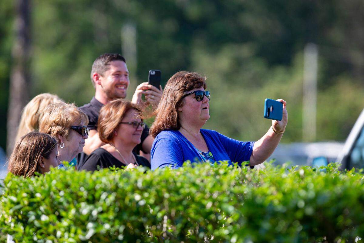 Onlookers stop by the ML Brown building in Conway Wednesday, hoping to get a glimpse of President Trump. Trump visited the Carolinas to meet with flood victims and those that were affected by Hurricane Florence.