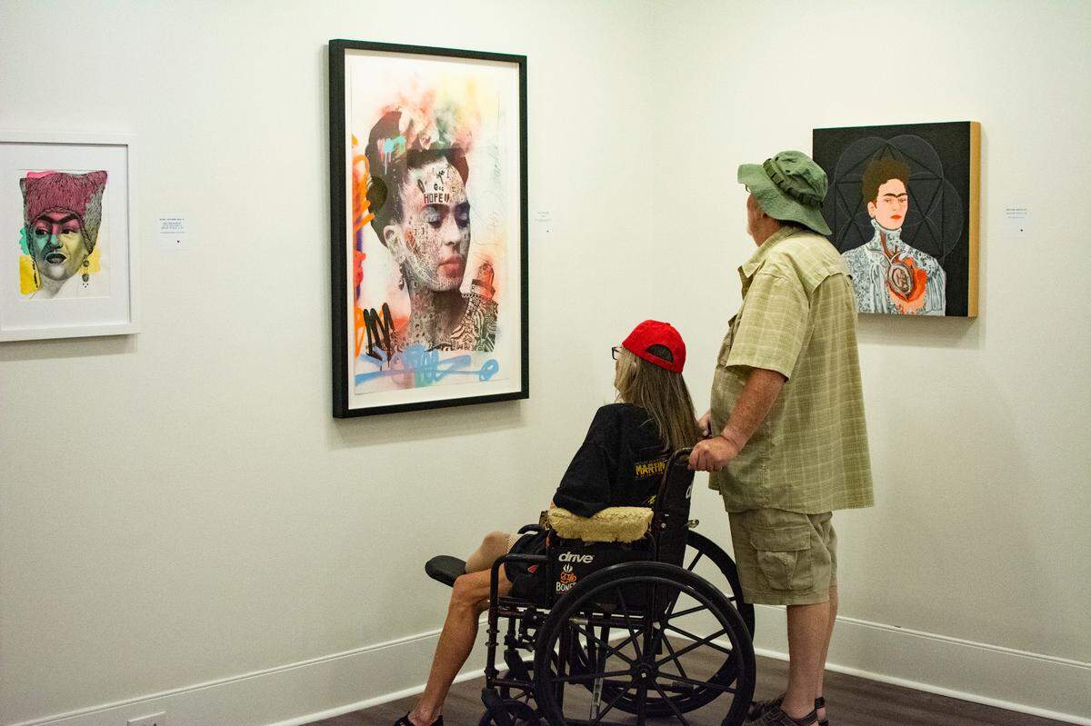 Two people visit the Myrtle Beach Art Museum’s summer 2022 exhibit, “The World of Frida.”