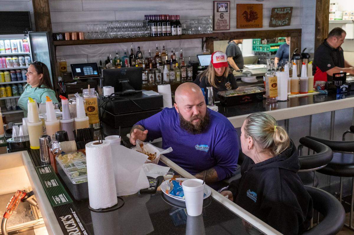 Josh Burnette eats lunch with his wife Ashley at Neal and Pam’s Bar and Grill in Surfside Beach, S.C. Burnette is credited with saving the popular restaurant from complete destruction as noticed the fire at 4a.m. while pressure washing on in July 2022. The eatery should reopen this week according to the owner. March 27, 2022.