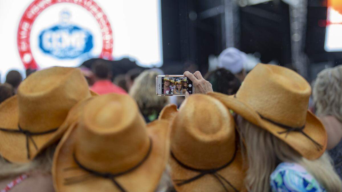 Mickey Maguire of Boston, MA. (L), Erin Romano of Vienna, Va., Carol Romano and Glenna Harris of Falls Church, Va. (R) take a selfie in the VIP area Thursday afternoon on the first day of Carolina Country Music Fest.