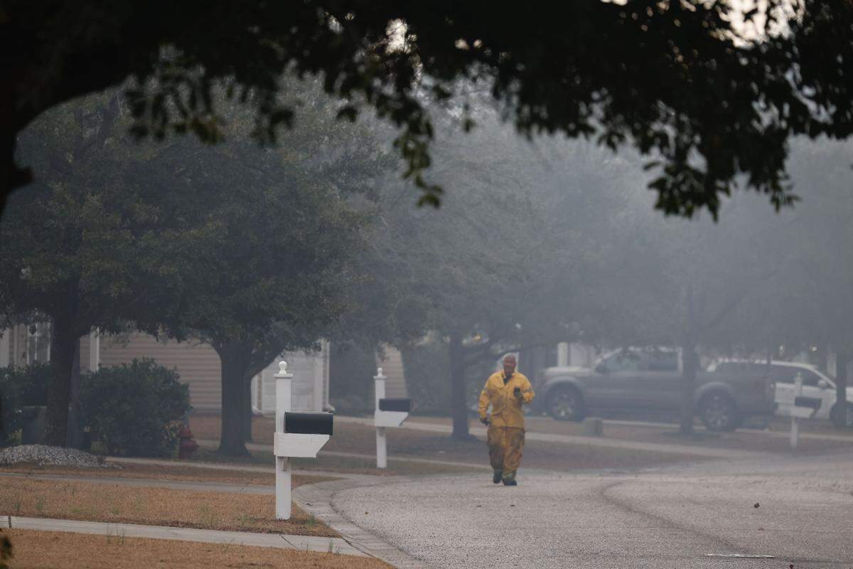 A fireman patrols smokey streets in the Reserve at Walkers Woods in the Carolina Forest area as wildfires enter their fifth day in the Myrtle Beach area. The blaze impacts more than 2,000 acres of land with strong winds and occasional rain possible March 5, 2025.