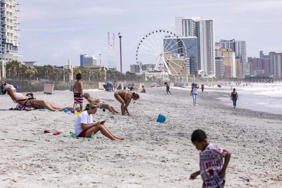 Sun bathers and walkers visit the 2nd Avenue Pier area of Myrtle Beach on Wednesday. Public beach accesses have re-opened in Myrtle Beach after being closed for weeks due to the coronavirus. Myrtle Beach, S.C. April 29, 2020