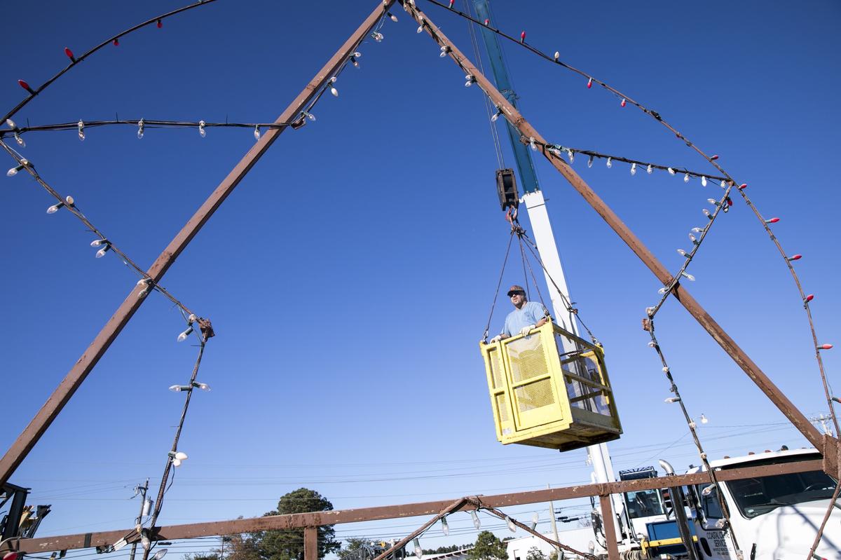 Tim Holmes inspects a 20 foot star that hangs from a crane on Seaboard Street.