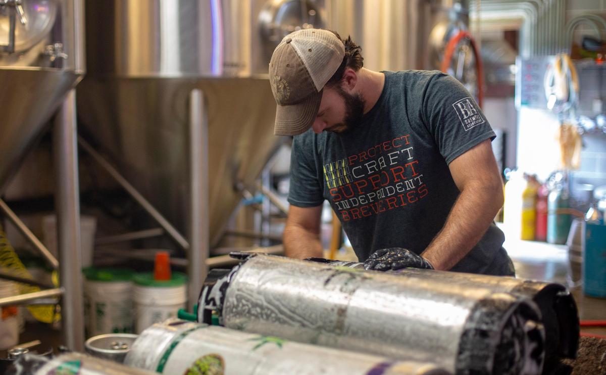 New South Brewery employee Chris Barnes cleans equipment at New South Brewery in Myrtle Beach on July 30.