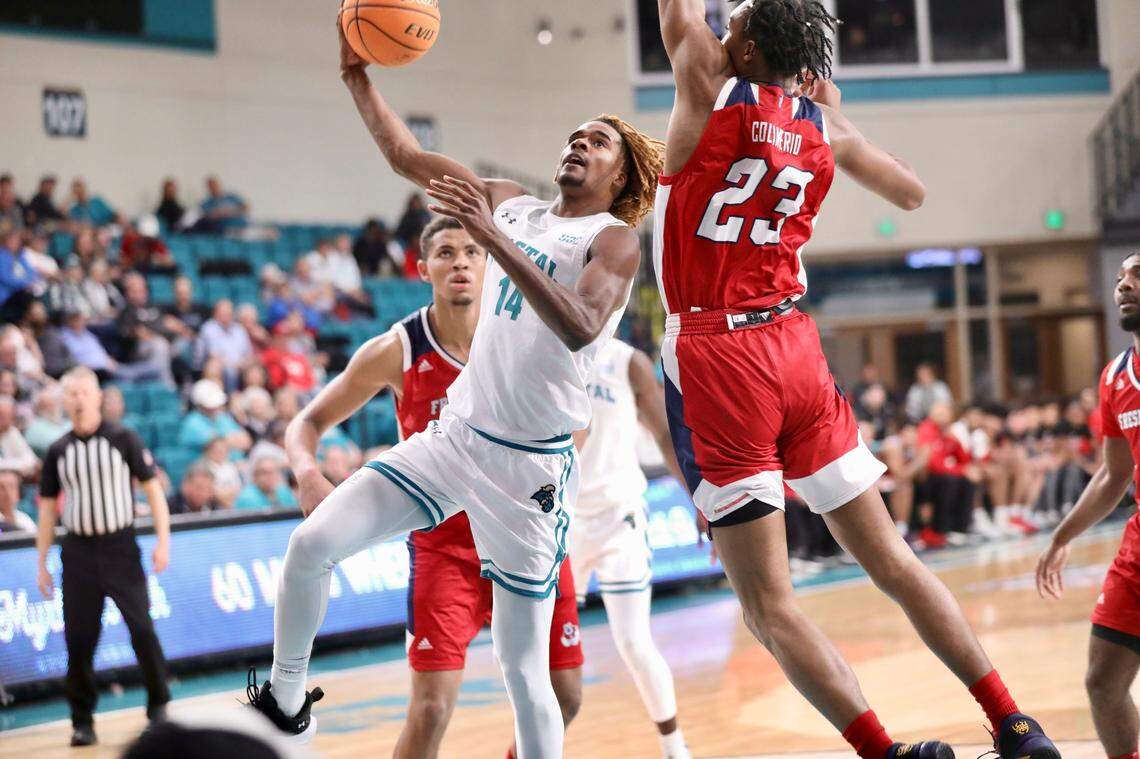 Coastal Carolina’s Josh Uduje scores over the defense of Fresno State’s Leo Colimerio (23) during the Chanticleers’ 85-74 loss in The Basketball Classic championship game at the HTC Center in Conway SC on Friday night.