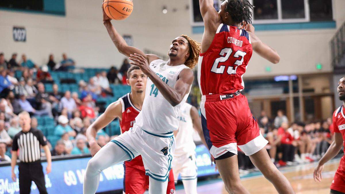 Coastal Carolina’s Josh Uduje scores over the defense of Fresno State’s Leo Colimerio (23) during the Chanticleers’ 85-74 loss in The Basketball Classic championship game at the HTC Center in Conway SC on Friday night.