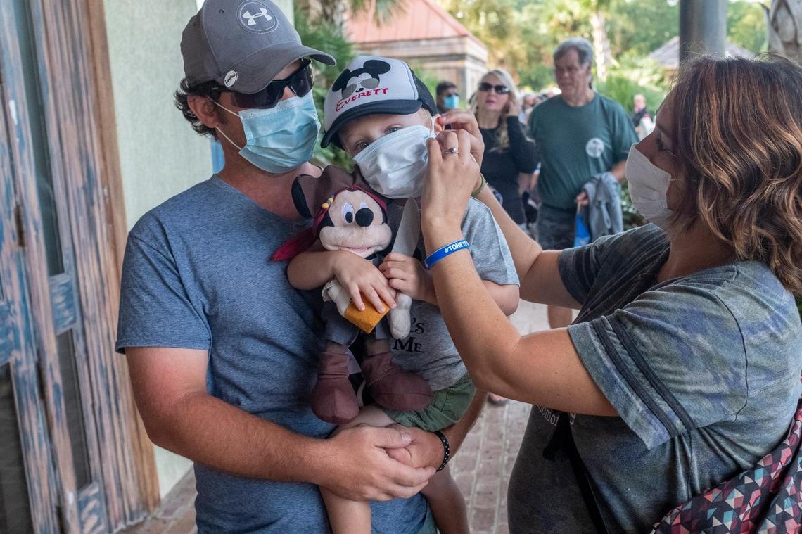 A family from North Carolina wearing masks waits to be allowed into Pirates Voyage on Tuesday. The dinner show reopened at partial capacity in Myrtle Beach last week with new rules during the coronavirus pandemic such as temperature checks, social distances and the wearing of masks for all patrons and service staff. September 14, 2020.