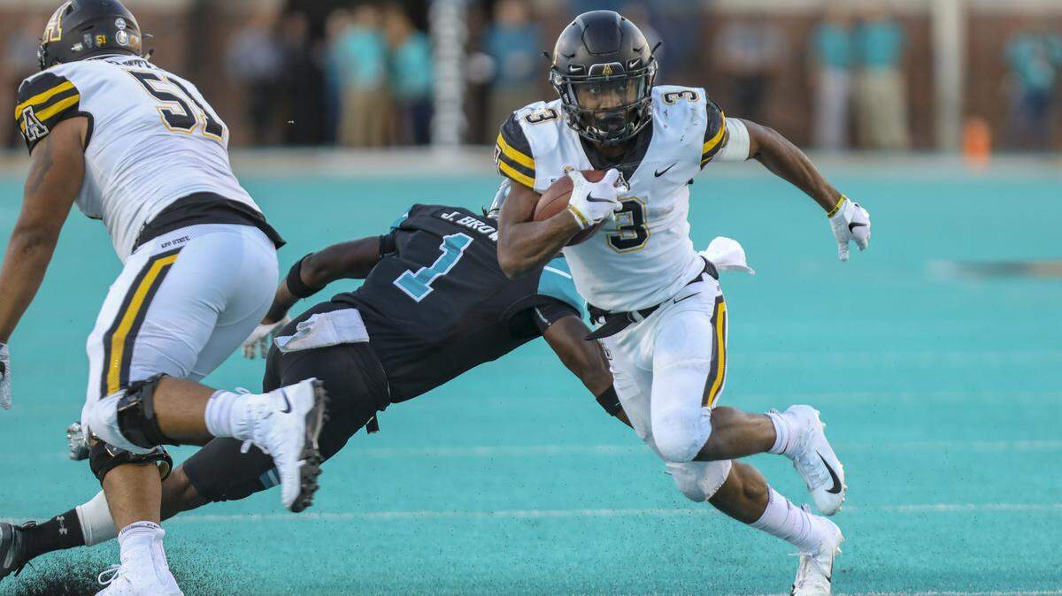 Appalachian State sophomore running back Darrynton Evans runs past Coastal Carolina safety Jave Brown on Saturday at Brooks Stadium in Conway.