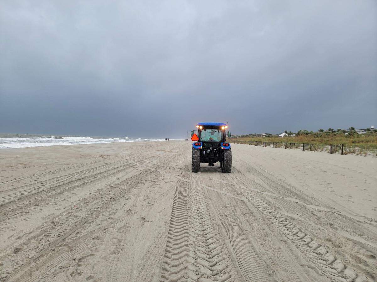 A John’s Beach Service truck picks up lifeguard equipment in rain from Tropical Storm Debby.