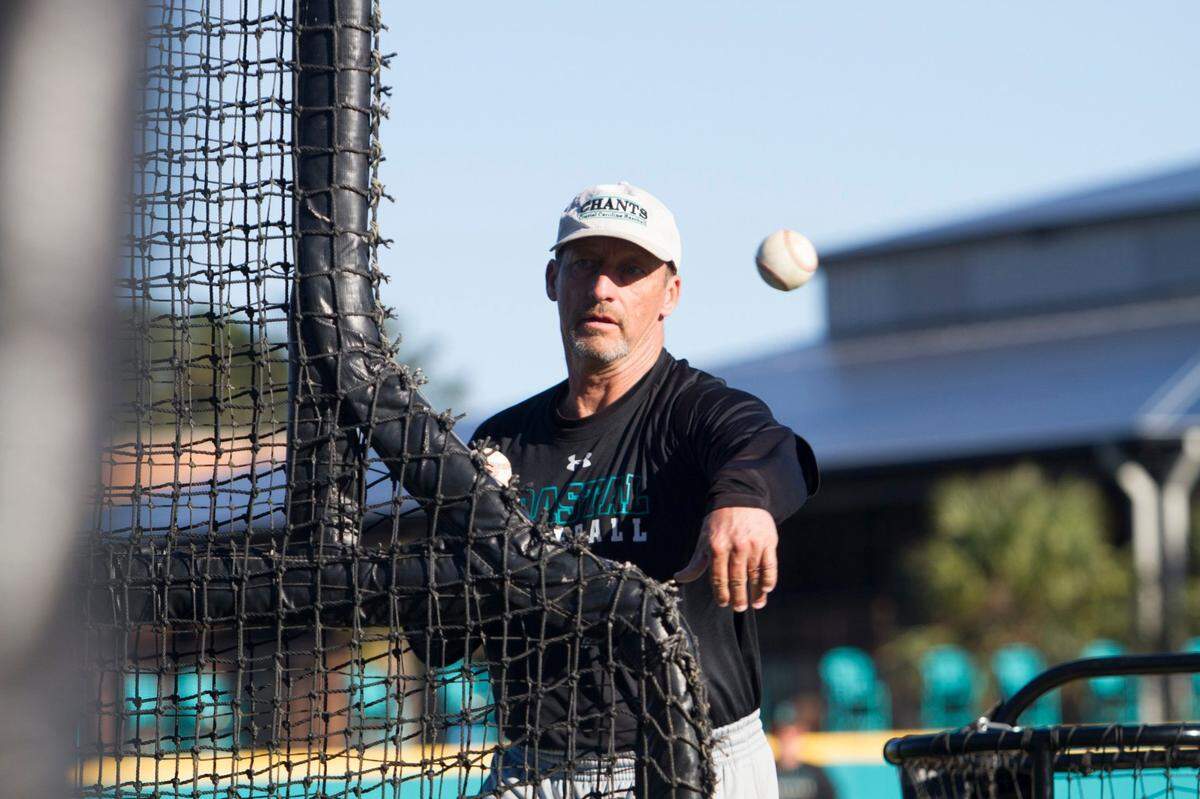 Coach Gary Gilmore throws pitches during batting practice on Thursday. The Coastal Carolina baseball team practices in uniforms with targets on their backs. The 2016 College World Series Champions, the CCU team is preparing to defend their title. Thursday, Feb. 16, 2017.