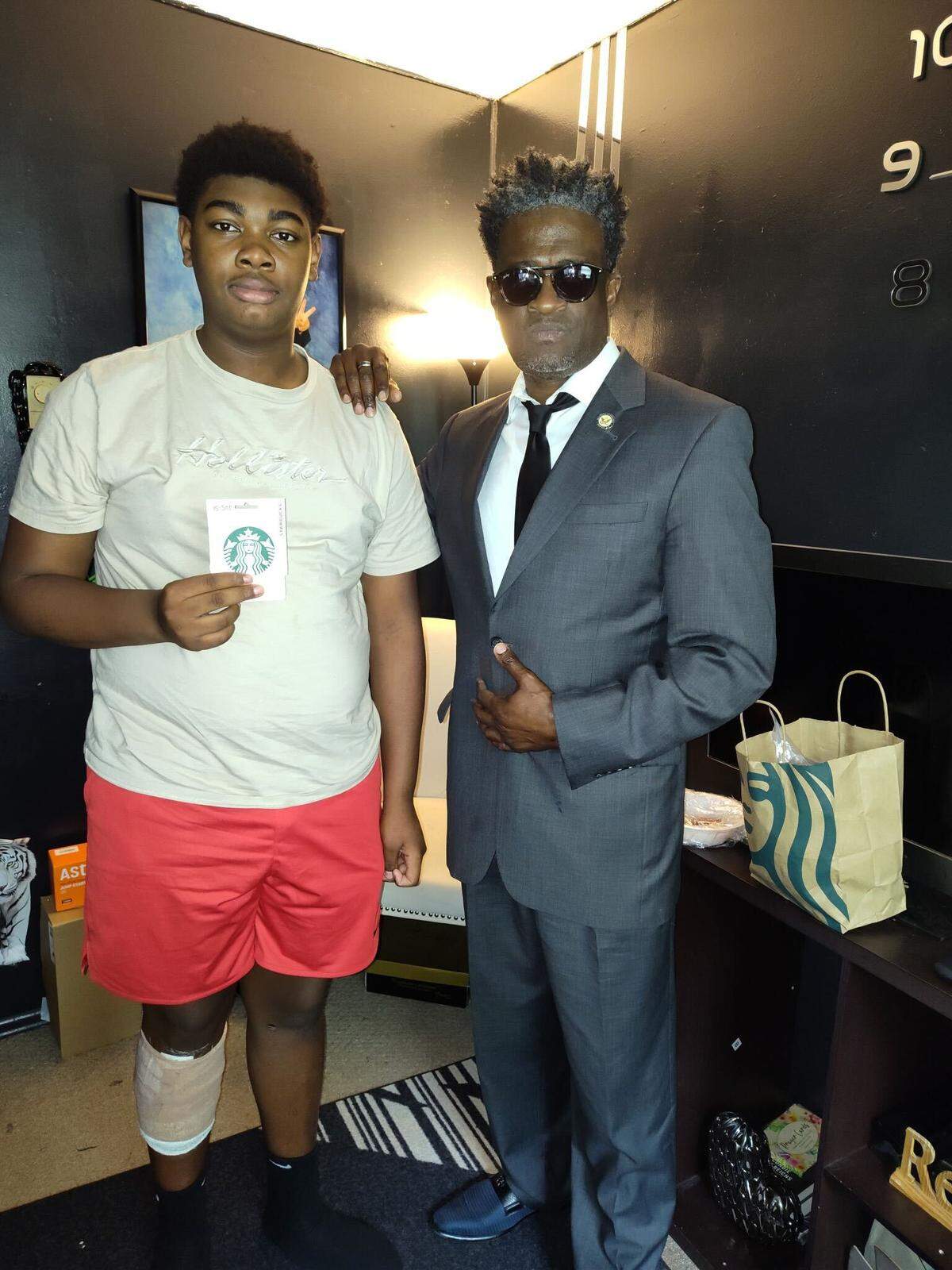 Zavian Hairston (left) poses with civil rights activist John C. Barnett (right). Hairston was shot in the leg and arm during a mass shooting in Myrtle Beach.