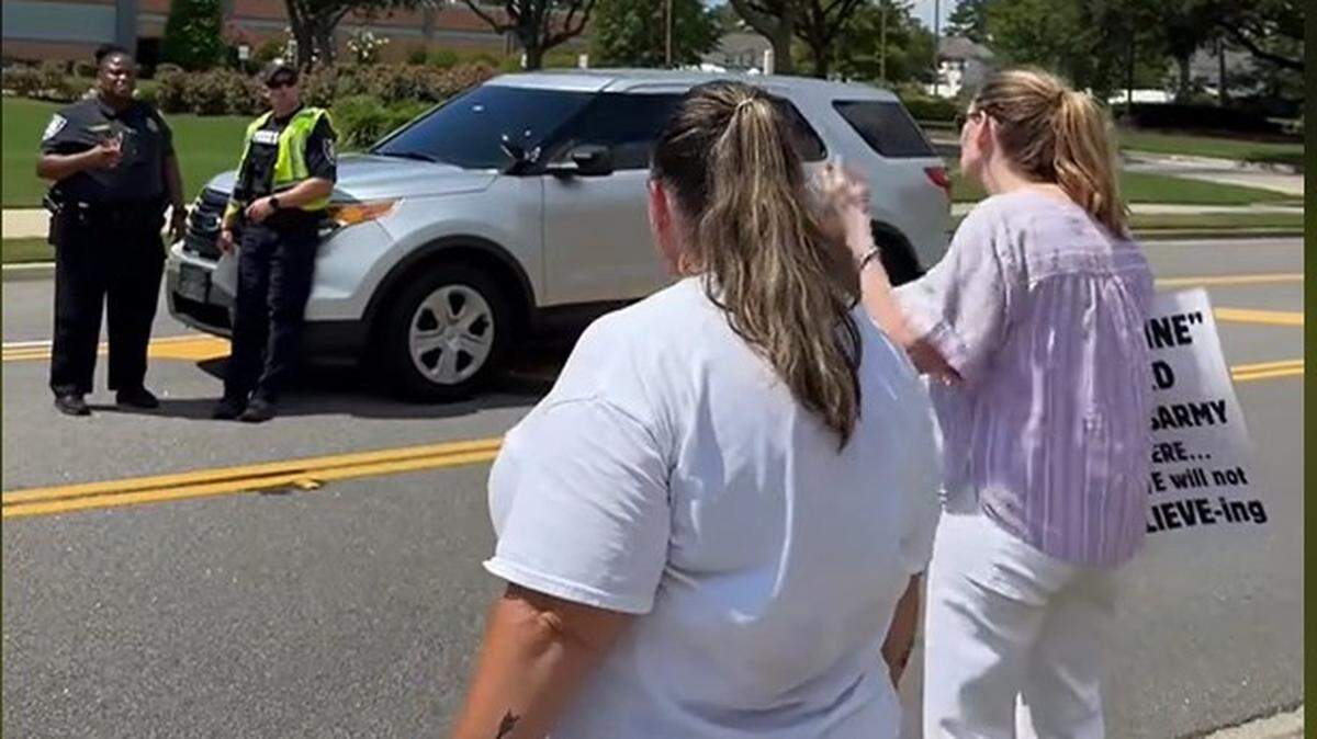 Protesters at Solid Rock Church in Myrtle Beach, SC, on Sunday, June 30, 2024, talk with police. A video shows protesters being sprayed by an apparent church member.